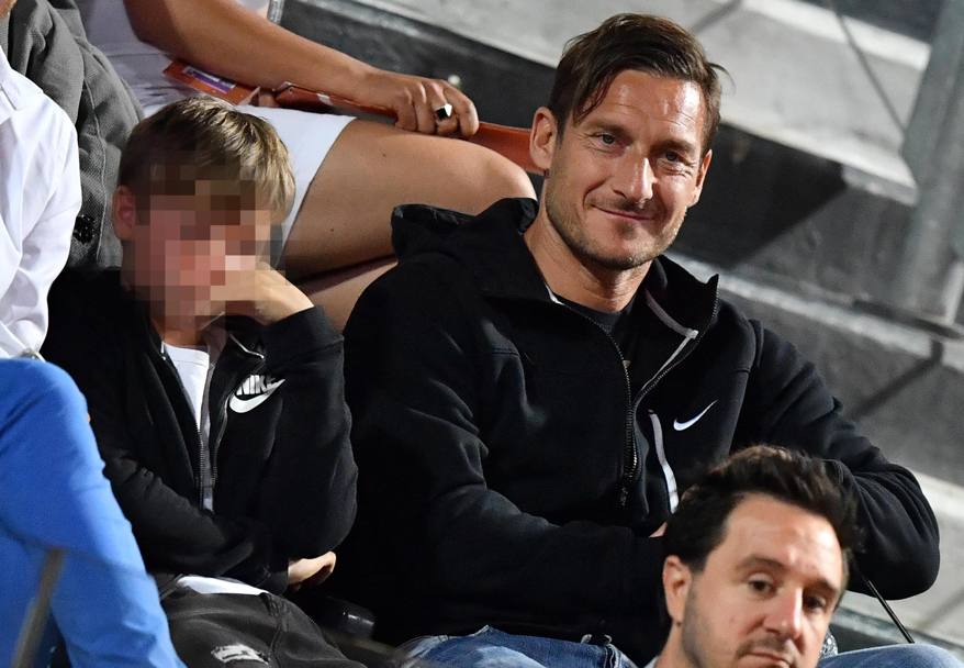 Francesco Totti divertito in tribuna con il figlio accanto